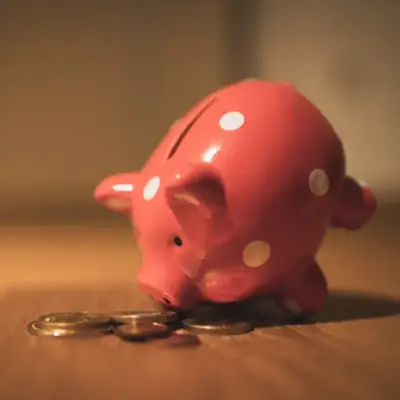 A piggy bank is tipped over with coins spilling out.